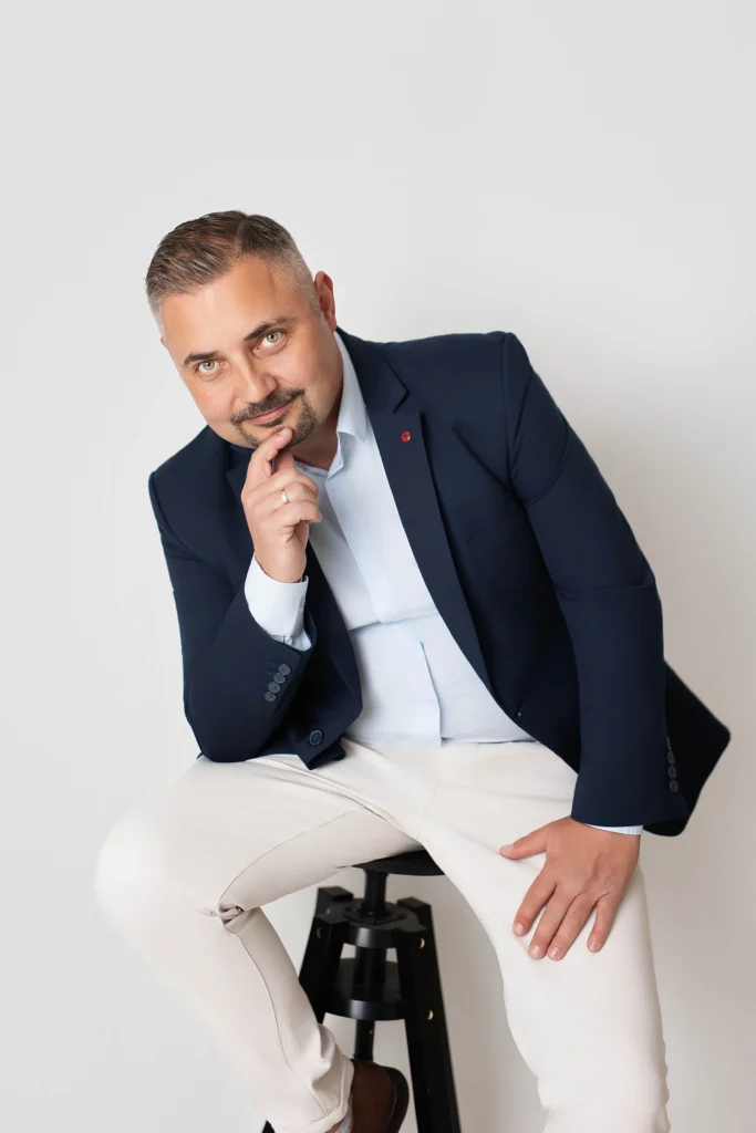 Specjalista od trudnych nieruchomości Łasica Home Solutions siedzący w granatowej marynarce – kim jestem